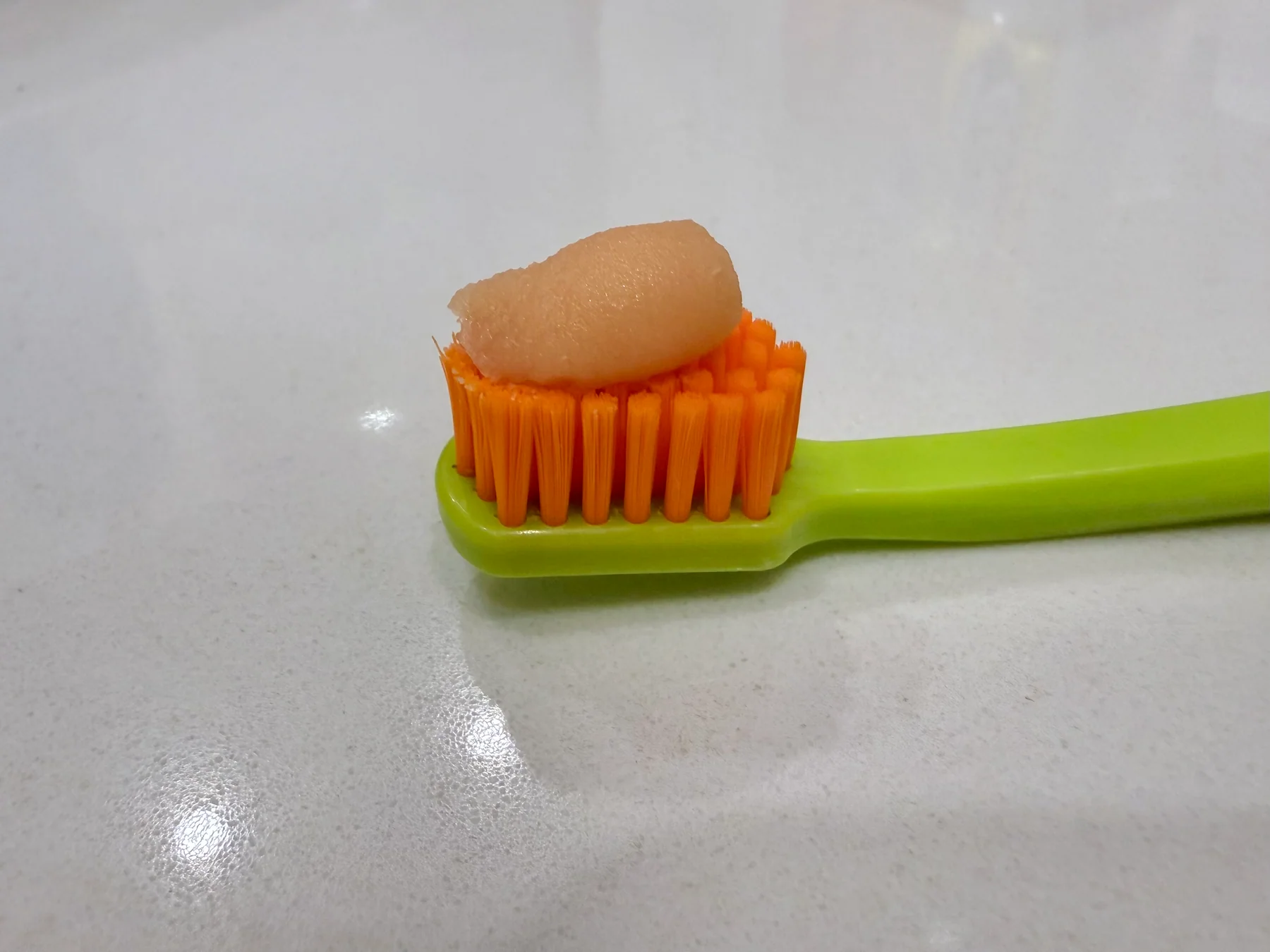 MARA EXPERT Paromed toothpaste on an orange and green toothbrush