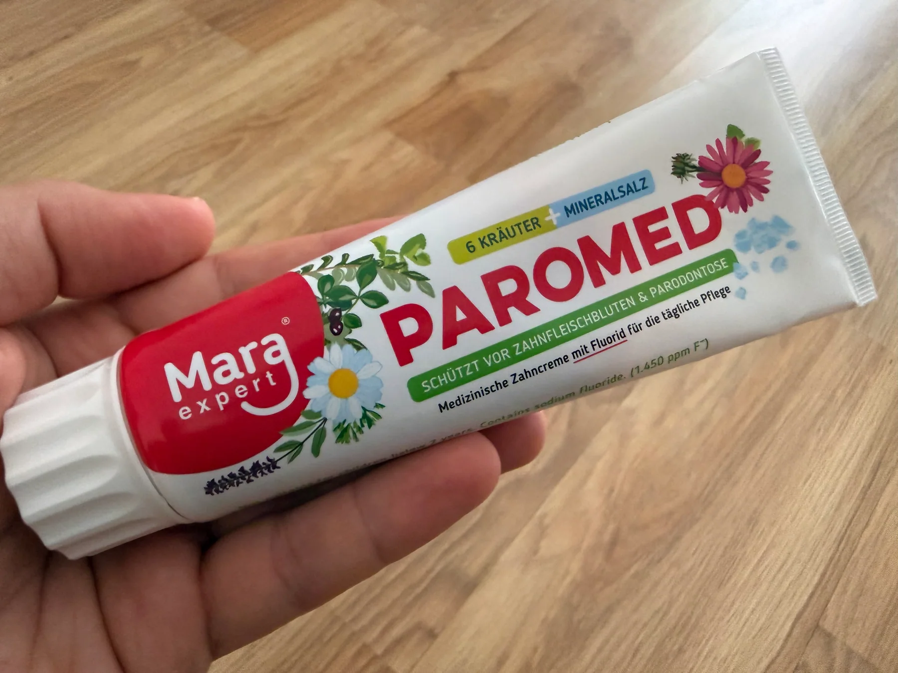 A tube of MARA EXPERT Paromed toothpaste held in one hand