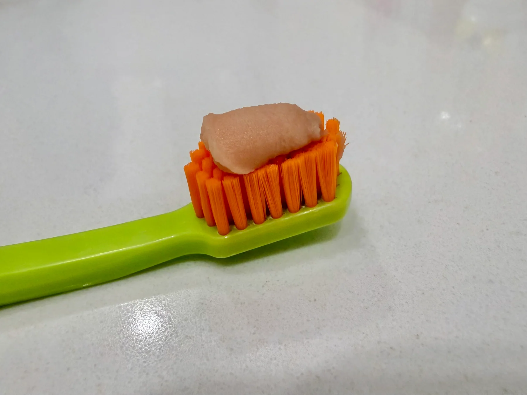 Old Parodontax toothpaste on an orange and green toothbrush